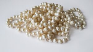Cremefarbene Perlenkette auf hellem Untergrund als Symbol der Perlenhochzeit zum 30. Hochzeitstag